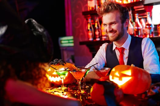 Happy barman welcoming guests on Halloween party