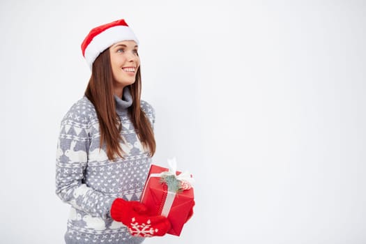 Happy woman with Christmas gift standing in isolation