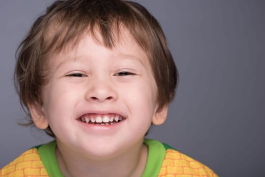 A happy 3 year old Japanese/Caucasian boy smiling.