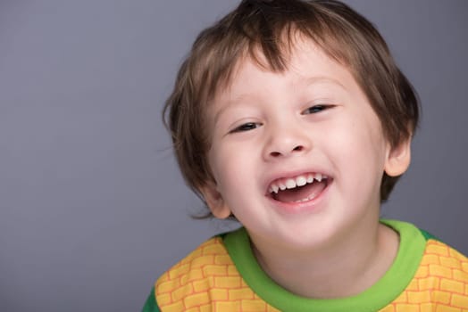 A happy 3 year old Japanese/Caucasian boy smiling.