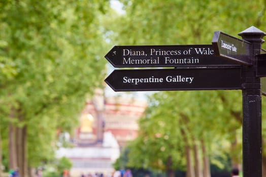 Direction sign in Kesington Gardens, London, UK, with arrow to Diana, Princess of Wales Memorial Fountain, and to the Serpentine Gallery.