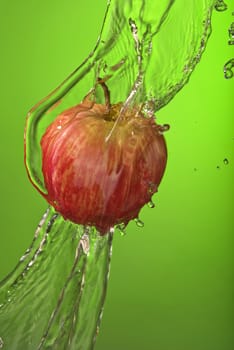 Healthy living organic apple on green background with water splash. Ideal for exercise campaign or poster. .