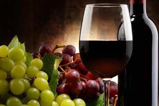 Composition with glass, bottle of red wine and fresh grapes