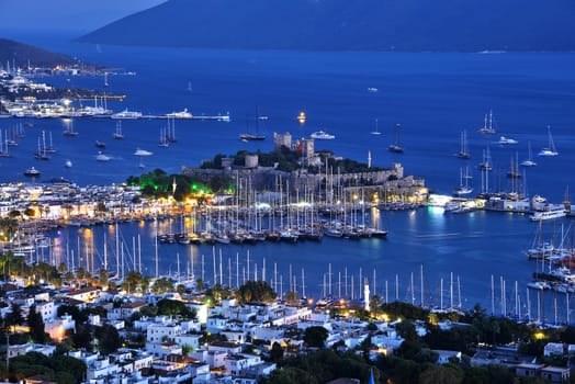 View of Bodrum harbor and Castle of St. Peter after sunset. Turkish Riviera.