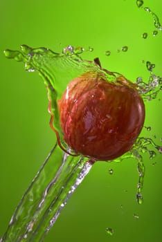 Healthy lifestyle apple water splash over green background. Ideal for nutrition campaign or website.