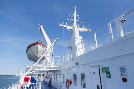 Ship deck with lifeboat and radar mast of a ferry
