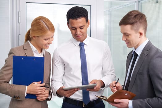 Group of colleagues discussing electronic data in office
