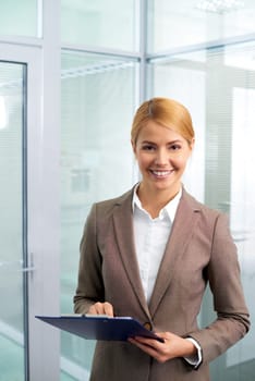Happy businesswoman looking at camera in office