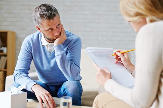 Tense man looking at his psychologist during consultation