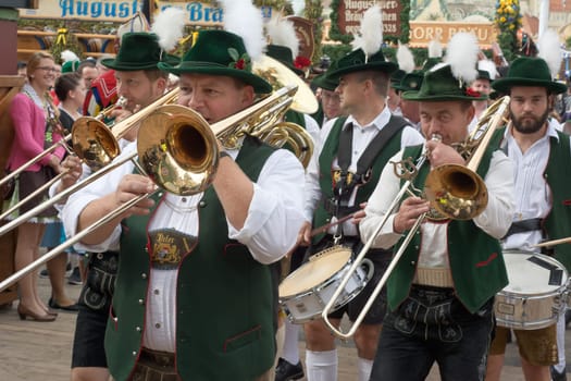 MUNICH, GERMANY – SEPT. 20, 2015: Traditional Marching Bands with Local Costumes entertain Crowds of visitors at the annual Oktoberfest. The Festival runs from September 19th until October 4th 2015 in Munich, Germany