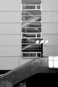 A lantern stands in front of a shiny tin facade with a stairway and an external staircase made of corrosion-free steel.