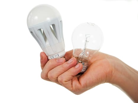 Hand holds LED lamp and incandescent lamp