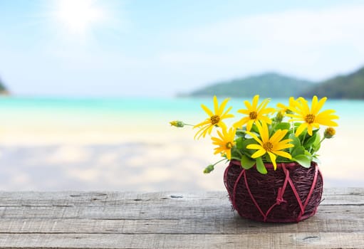 flower vase on wood table and beach background