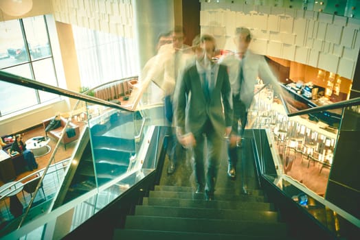 Blurred outlines of businessmen going upstairs