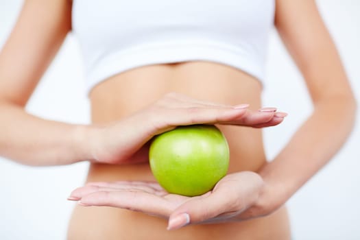 Slim female holding green apple between her palms