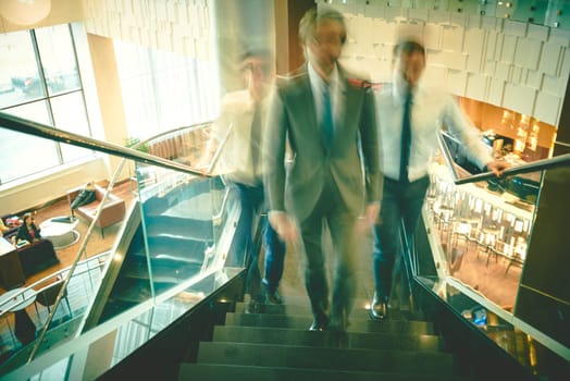 Blurred outlines of business group going upstairs