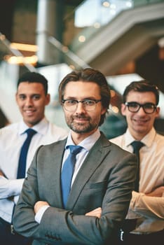 Confident businessman looking at camera on background of two employees
