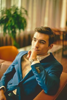 Young handsome businessman sitting on sofa