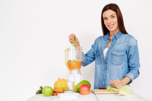 Pretty girl putting cut Chinese cabbage into vegetable smoothie