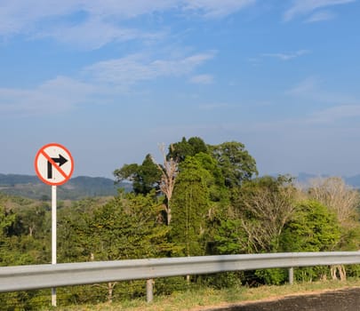 Right-turn prohibition sign with mountain background in Thailand