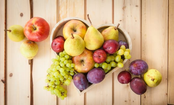 Fresh autumn fruits on rustic wooden background