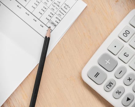 Paper for finance with pencil and calculator on wooden background