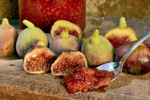 Composition of fig fruits on a wooden board and rocks in the background.