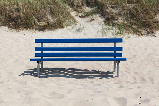 Blue bench in beach sand
