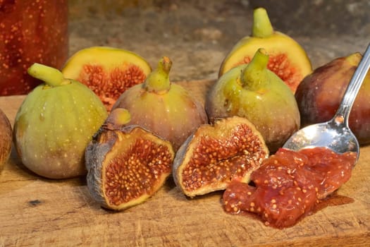 Composition of fig fruits on a wooden board and rocks in the background.