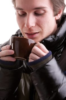 portrait of a good looking young man having a hot drink in winter