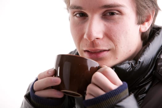 portrait of a good looking young man having a hot drink in winter