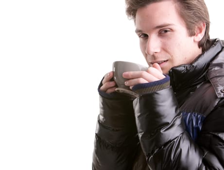 portrait of a good looking young man having a hot drink in winter