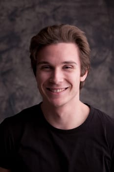 handsome young man happily doing something while watching at camera