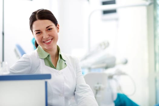 Pretty assistant in uniform looking at camera in hospital