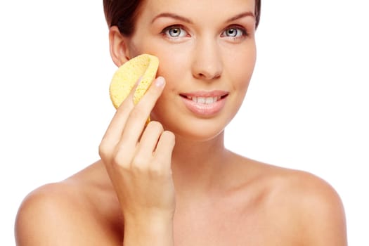 Fresh woman with sponge cleaning her face