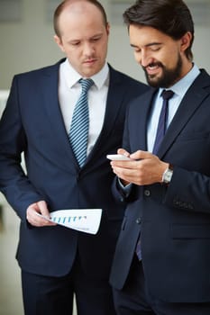 Two male employees using cellphone