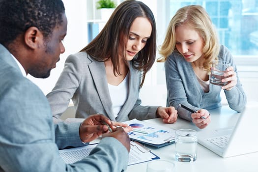Business team analyzing financial document at meeting