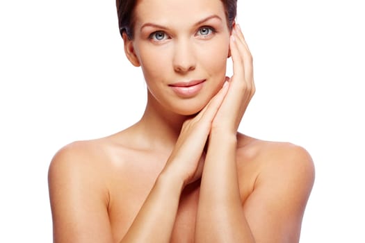 Naked woman keeping her hands by face and looking at camera