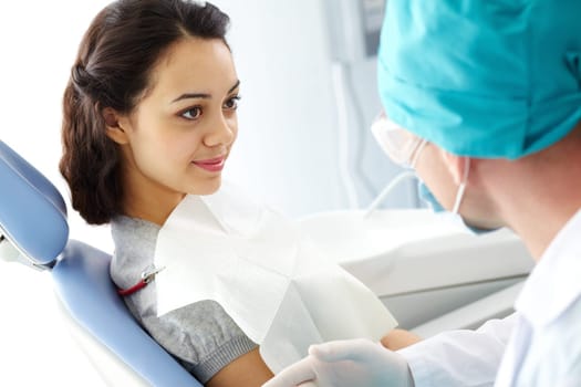 Young girl listening to dentist in dental clinic