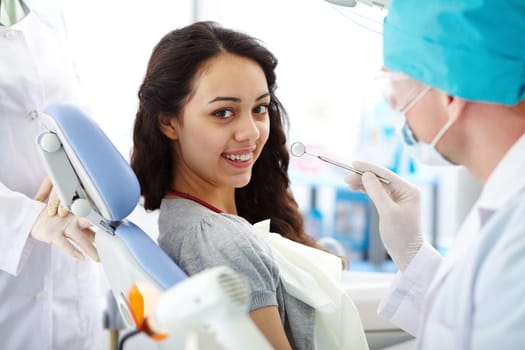 Cute brunette with toothy smile looking at camera before dental check-up