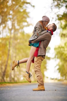 Happy guy holding his girlfriend during date in park