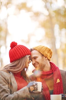 Amorous young couple with tea relaxing outdoors