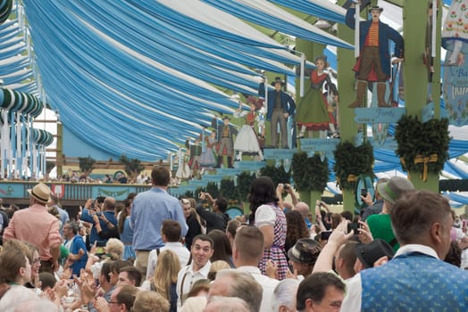 MUNICH, GERMANY – SEPT. 19, 2015: Oktoberfest Crowds of Visitors at the Spatenbrau Tent celebrating the festivities and beer. The Festival runs from September 19th until October 4th 2015 in Munich, Germany.