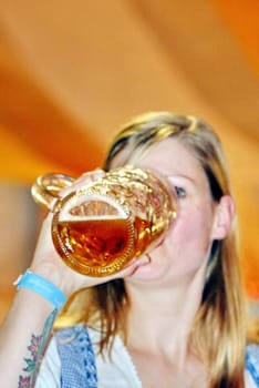 A woman drinks a measure of beer at Oktoberfest Konstanz 2015