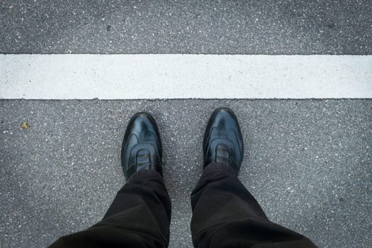 2 legs with shoes stand on the strip in white