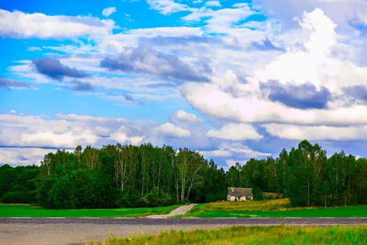 Landscape with Single House Near the Road Throuth Green Trees with Blue Sky and Clouds