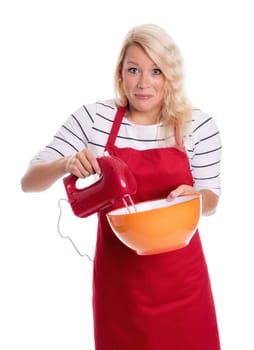Woman in apron stirs with a blender in a bowl