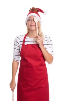 Christmas woman in apron holds cooking spoon in front of her eyes