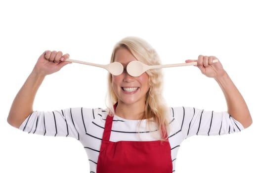 Woman in apron holds wooden spoon in front of her eyes
