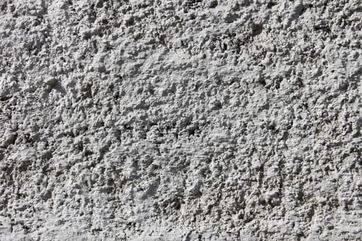 Fragment of concrete wall painted with white lime